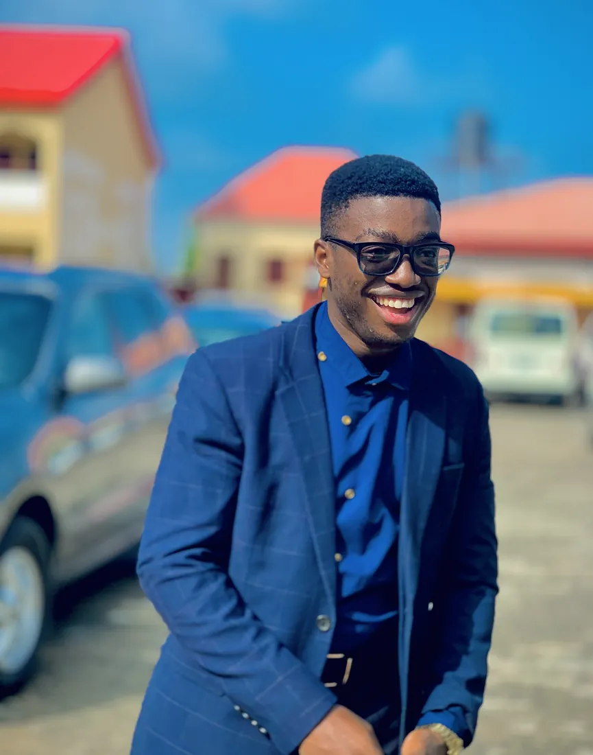 Gabriel Obisike, smiling, in a navy suit